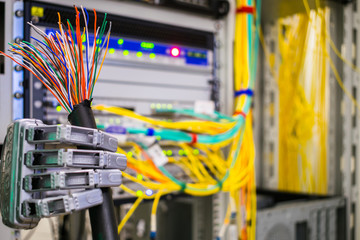 A mechanical robot arm holds a damaged Internet cable in the data center server room