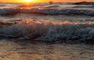 Sunset over the sea. Reflection of sunlight in the sea waves. Red sky in the rays of the sunset.