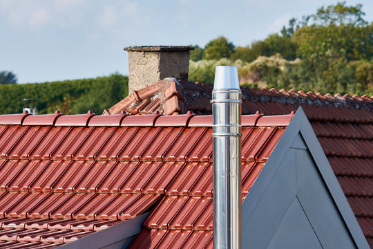 modern chimney on a roof of a house, clean metal chimney pipe