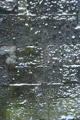Medieval stone wall is covered with snow, design background with copy space, background on winter