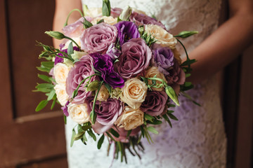 young beautiful bride in white dress holding wedding bouquet, bouquet of bride from rose cream spray, rose bush, rose purple Memory Lane, violet eustoma, eucalyptus .