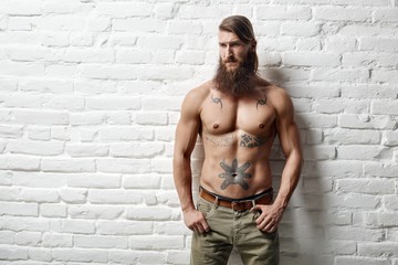 Young muscular bearded white man half naked