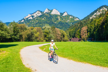 Young woman cycling near Trzy Korony (Three Crowns) sunny autumn day, Pieniny Mountains, Poland © pkazmierczak