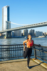 Woman stretching under the Manhattan bridge