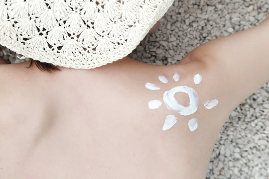 Woman with sun shaped sunscreen on her shoulder