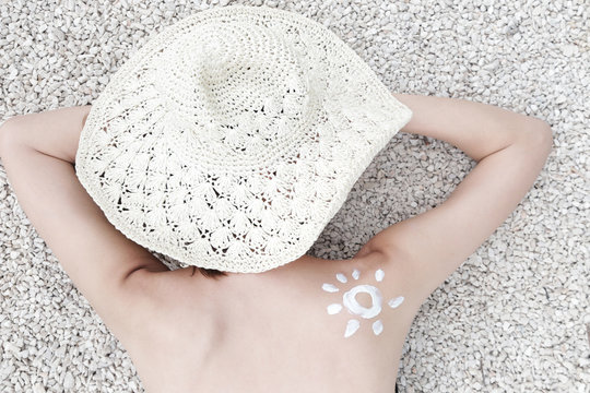  Woman with sun shaped sunscreen on her shoulder