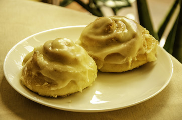 Two rolls, a cake on a coffee table in a cafe.