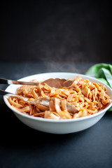 Seafood pasta in a large white bowl on dark background