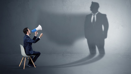 Fototapeta premium Humble businessman staying and offering stuffs to a huge businessman shadow