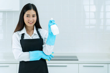 Housekeeper concept. Professional asian woman wearing aprons and rubber protective blue gloves...