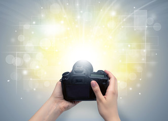Naked hand taking picture with digital camera and glowing flash concept
