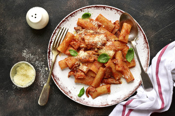 Pasta rigatoni in tomato sauce with chiken and parmesan cheese.Top view.