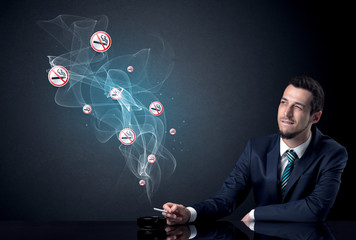 Businessman smoking with floating no smoking signs beside his head.