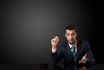 Businessman holding cigarette in his hand and wearing suit.