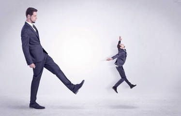 Big man in suit kicking out little himself out with simple white wallpaper
