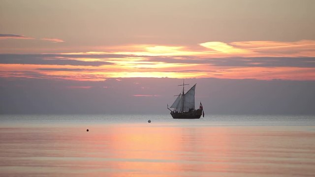 Sailing ship with masts in the sea at sunset in the Baltic Sea