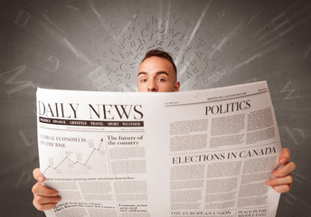 Young smart businessman reading daily newspaper with alphabet letters above his head