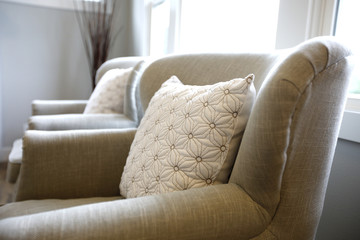 Close-up of an ivory armchair topped with a pillow