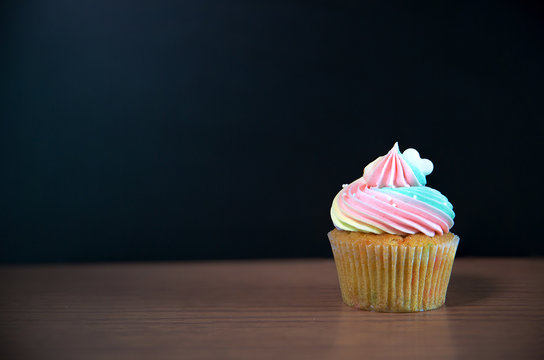 Birthday cupcake in front of a chalkboard.mini cake.chocolate cupcake with rainbow cream and heart for love valentines.image for background, wallpaper and copy space.