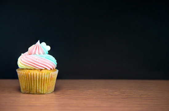 Birthday cupcake in front of a chalkboard.mini cake.chocolate cupcake with rainbow cream and heart for love valentines.image for background, wallpaper and copy space.