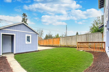 Obraz premium Large fully fenced back yard with a garage.