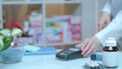Credit payment at drugstore. Close up of female hand give customer pharmatheutical pills to male customer. Electronic payment at pharmacy. Pharmaceutical business. Pos terminal at pharmacy store - Powered by Adobe