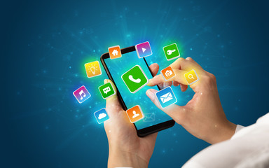 Female hand using smartphone with 3D shiny starlike application icons around
