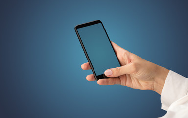Mockup for female hand using frameless smartphone with dark background

