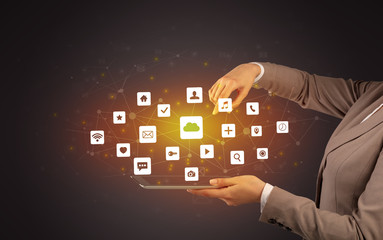 Female hand touching tablet with application icons above