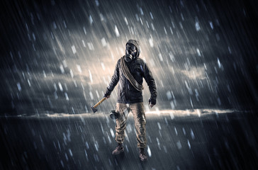 Terrorist in a stormy space with gas mask on his hand and weapons on his arm
