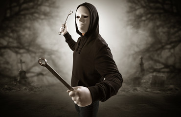 Armed aggressive hunter in abandoned thick forest graveyard concept
