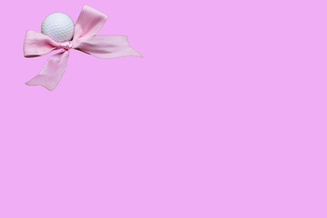 Golf ball with pink ribbon on pink background for golfer's girl baby shower