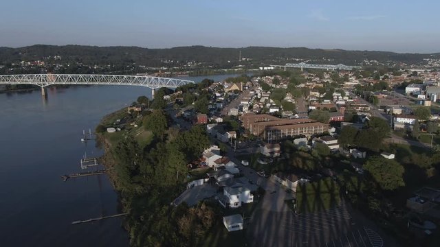 An evening forward aerial establishing shot of a small town on the Ohio River in western Pennsylvania at dusk. Pittsburgh suburbs.  	