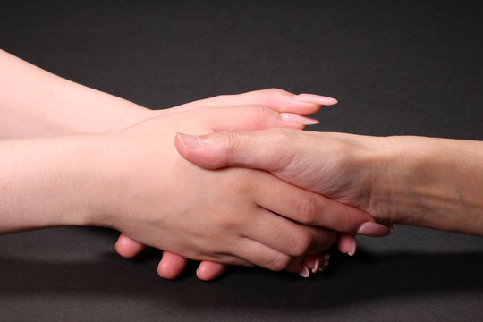 シニアの手を握る若い女性