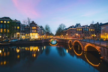 Obraz premium Night city view in Amsterdam, Netherlands. Canal and typical dutch houses at night in Amsterdam, Netherlands