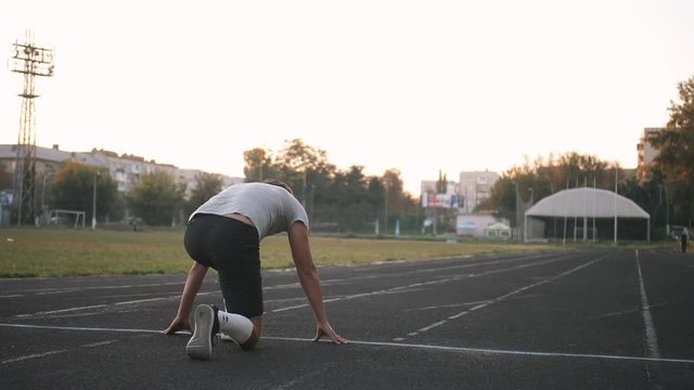 Mixed race athlete sprinter running on an all-weather running track alone