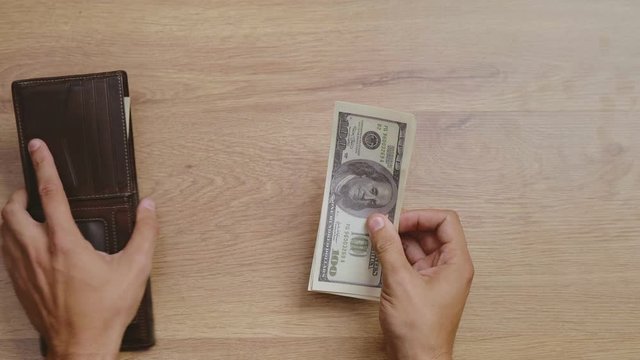 Male hands getting money out of wallet, counting