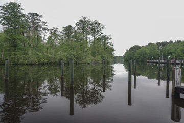 Pokomoke, Maryland, USA: Docks in the Pokomoke River State Park reflected in the calm, glassy waters of the river.