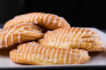 Danish pastries on a white plate against a dark background