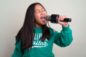 Portrait of young cute Asian girl wearing stylish clothes