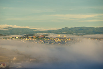 wonderful landscape of Da Lat city, early morning fog covering the city, far away is the green mountains, mist covered the greenhouse under the morning sun