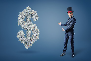 A businessman wearing a magician's hat and presents a large dollar sign made of many bills.