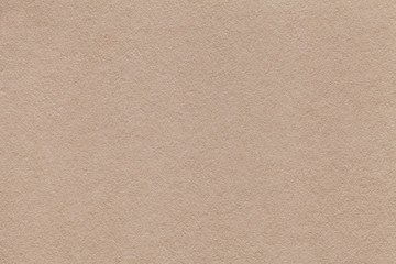 Texture of old beige paper closeup. Structure of a dense cardboard sand color. The background.