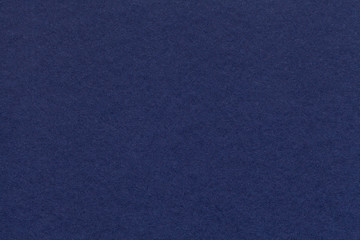 Texture of old navy blue paper closeup. Structure of a dense cardboard. The denim background.