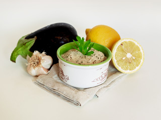 Middle Eastern cuisine- baba ghanoush closeup in a plate on the table