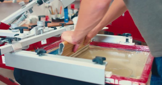 Silk screen printing process - making a print on a t-shirt. 4K UHD