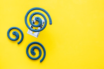 Mosquito repellent for outdoor: garden, summer house, picnic. Green spiral on yellow background top view copy space pattern
