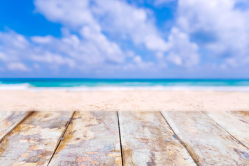 Fototapeta premium Wooden desk or plank on sand beach in summer. background. For product display
