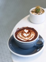 Hot Chocolate in a cup at coffee shop. hot drink with heart shaped latte art, Cafe with barista art concept.
