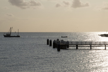 Obraz premium Fishing boat emptying the nets at sunrise